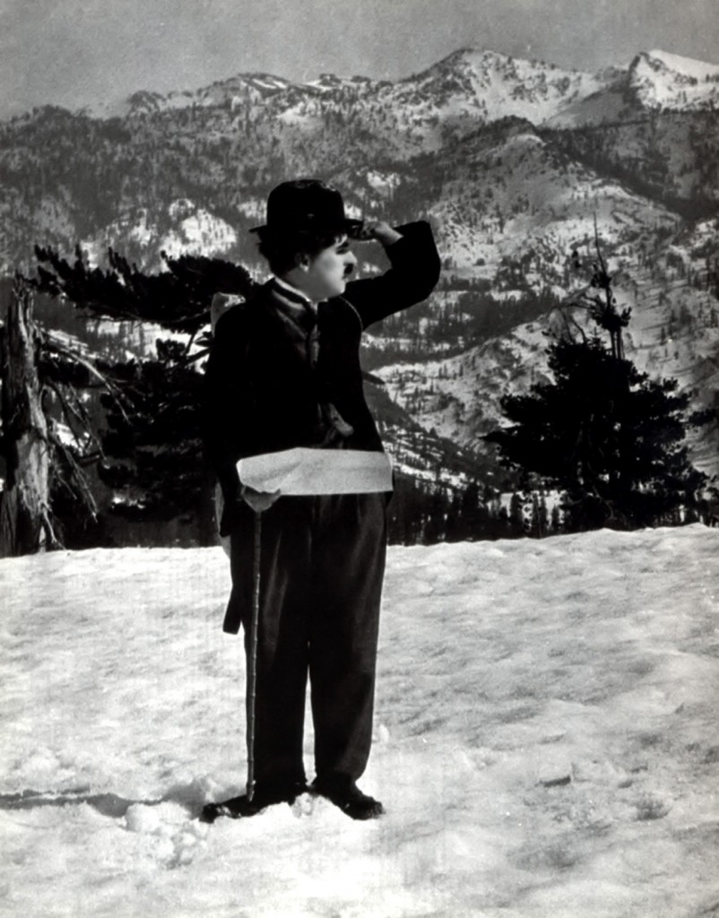Chaplin. Braving and conquering the elements in his city suit, the Lone Prospector surveys the terrain
