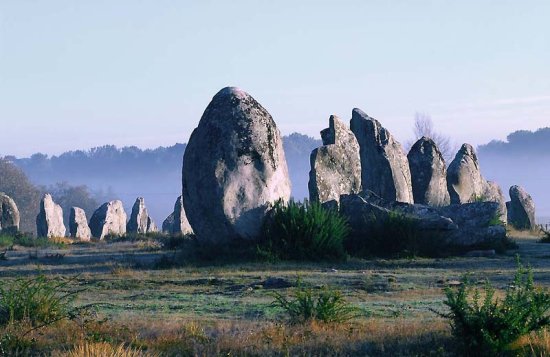Menhirs. standing like sentinels. Giant menhirs at Carnac ( Kermario ) in Brittany are part of a vast megalithic complex.
