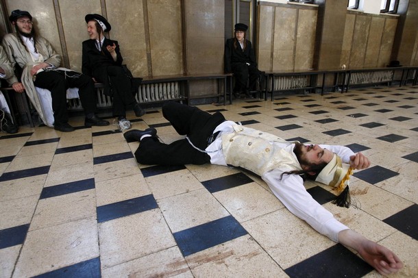 ---Reuters FILE - An ultra-Orthodox Jew lies on the ground drunk during celebrations for the Jewish holiday of Purim in a synagogue in Jerusalem March 23, 2008.---