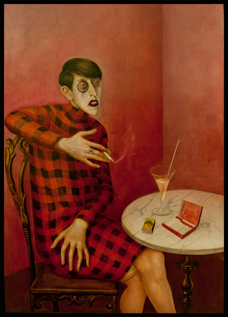 ---In the somewhat shocking portrait of the German writer, Sylvia von Harden sits at a café table, drinking a cocktail and smoking a cigarette.  She is ugly and androgynous.  Somehow, all of the reds in the painting clash and the plaid pattern along with her dark hair and monocle are jarring.  Her hands are claw-like and monstrous and the expression on her face is very unattractive.  The real lady was not a looker, but she was not nearly as unappealing as Dix portrayed her. Dix persuaded Von Harden to sit for him by exclaiming, “I must paint you! I simply must! You are representative of an entire epoch!” ---click image for source...